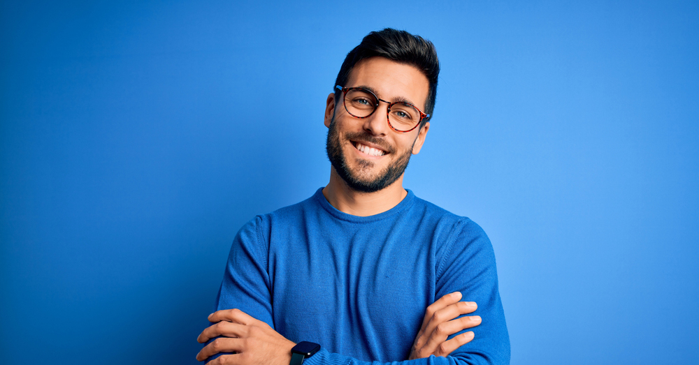 ragazzo sorridente con occhiali su sfondo blu